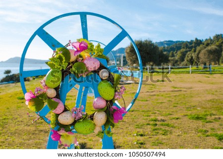 colorful easter eggs and branch with flowers by the sea