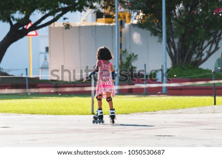 Little girl in a pink dress on roller skates, Male, Maldives. Copy space for text