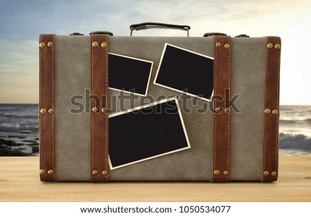 Image of old vintage luggage with blank photos for photography montage mockup over sea tropical landscape