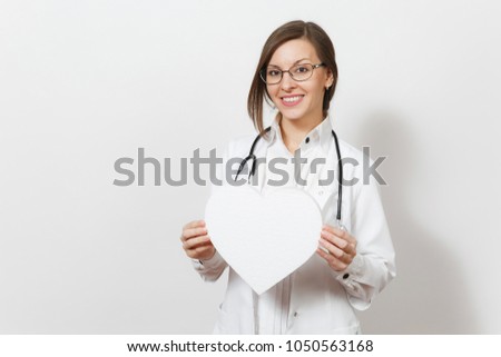 Smiling young doctor woman with stethoscope, glasses isolated on white background. Female doctor in medical gown holding white heart with place for text Copy space advertisement. Healthcare personnel