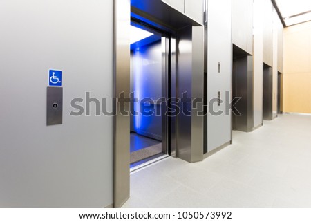 disabled signage, Modern steel elevator opened cabins in a business lobby or Hotel, Store, interior, office,perspective wide angle. Three elevators in hotel lobby.