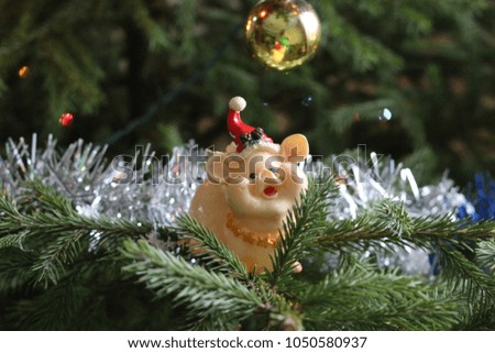 a picture of the New Year's plot. a Christmas tree with a toy figure of the symbol of 2019, a yellow earth pig. A beautiful and cozy New Year's picture.