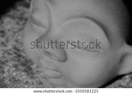 stone head with closed eyes