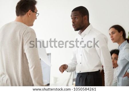 Diverse black employee and white boss arguing in office, african worker disagreeing with dismissal firing protecting rights or behaving rudely, multiracial conflict at work and racial discrimination Royalty-Free Stock Photo #1050584261