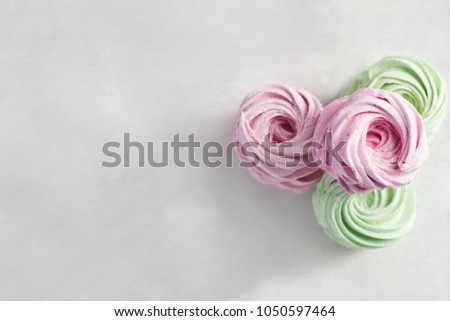 Homemade green and pink zephyr or marshmallow on white wooden background. Marshmallow, Meringue, Zephyr