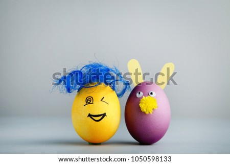 Eggs with funny faces on grey background