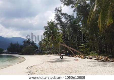 Photo of coastal zone with trees against backdrop of hills
