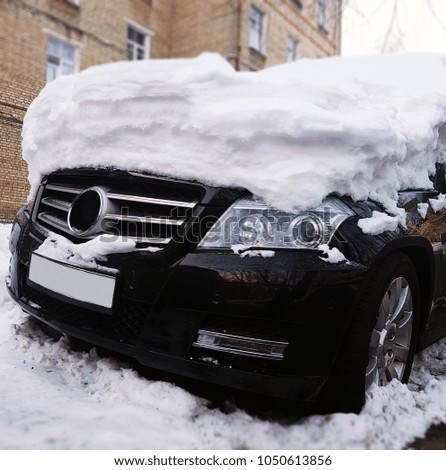 Photo of black car with snow on hood at street