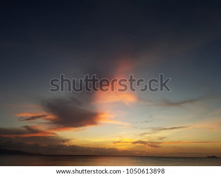 Photo of crimson sky and sea coast with boat at sunset
