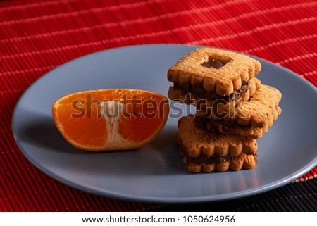Group of chocolate Halloween cookies on plate and red and black background