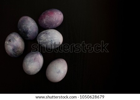 Painted eggs on a black background similar to a space planet background
