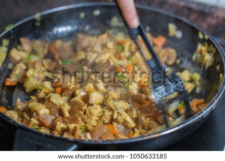 Cooking burrito in a pan with chicken, pepper, tomato for fajitas typical Latin America food
