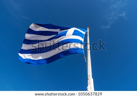 Flag of Greece on flagpole against the blue sky