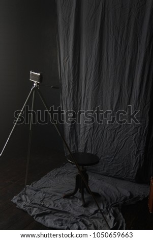The old camera on a tripod stands in the room