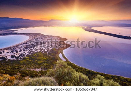 Amazing sunrise view with multicolored clouds from  Castle. Romantic sunset on Voidokilia beach, Ionian Sea, Pilos town location, Greece, Europe. View of the ocean through the rocky shore