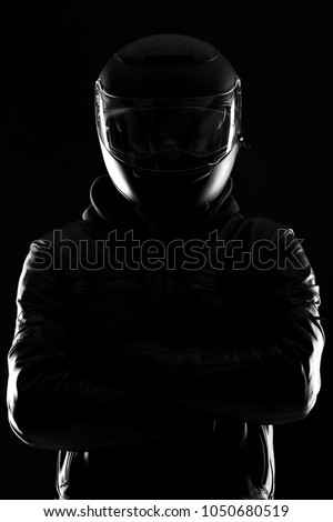 Portrait of a biker before black background. Low key.
