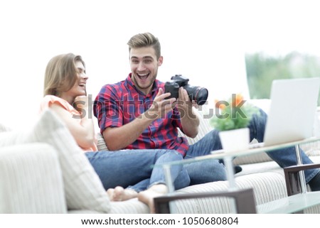 modern young couple laughing and discussing the photos on the camera