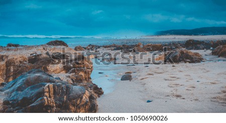 Beach sand and rocks in seascape.