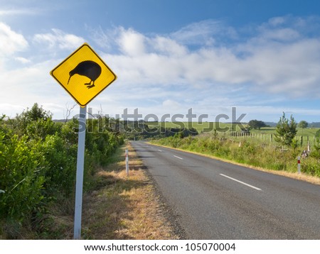 New Zealand Road Sign, Attention Kiwi Crossing beside country road warning motorist to watch out for this endangered icon of NZ