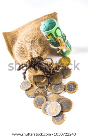 Bag with coins and one hundred euro banknote tied up with rope isolated on white background