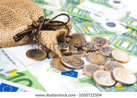 Bag with coins on one hundred euro banknote background