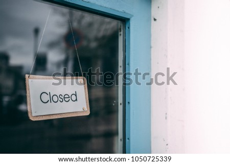 Glass door with the closed sign on the door and white wall space for text