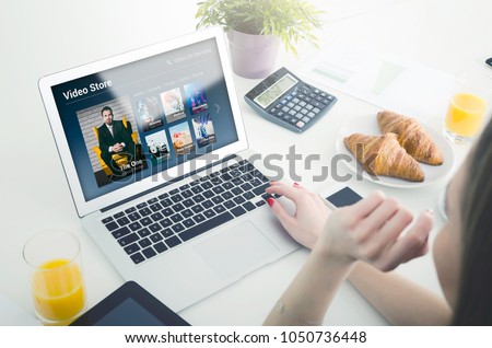 Woman using laptop for watching movie on VOD service. Video On Demand television internet stream multimedia concept