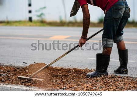 Asian man are working at the road construction asphalt pavement for road repairing