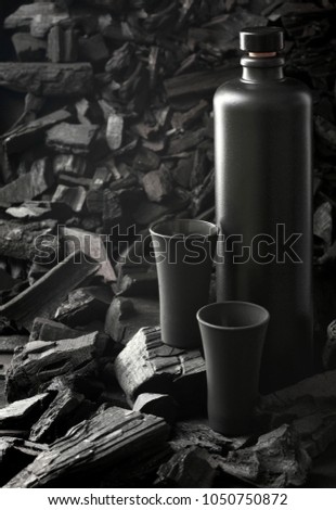 Original black matte bottle of vodka or tequila and black shot glass .On charcoal background. Black edition.Creative.Let's drink.Cheers.Mockup.Copy space.Pour it.Still life Royalty-Free Stock Photo #1050750872