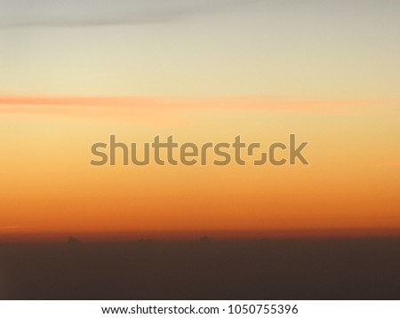Horizon line of orange sky and clouds with beautiful golden orange sunset time with light sunrise nature, picture from plane.