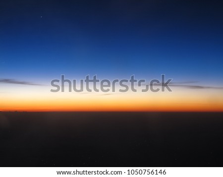 Horizon line of blue sky and clouds with beautiful golden orange sunset time with light sunrise nature, picture from plane.