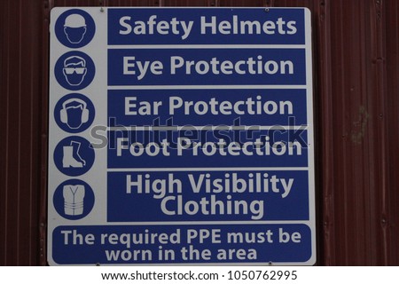 Personal Protective Equipment (PPE) Sign stuck on a Galvanized Fence at a Construction Site