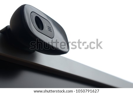 A modern web camera is installed on the body of a flat screen monitor. Device for video communication and recording of high quality video