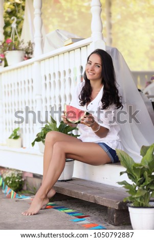 Young girl on the porch of the house eating a sweet watermelon