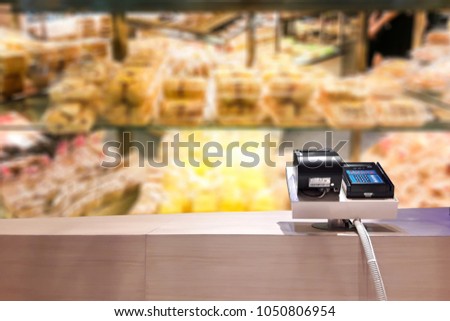Look out of the payment counter, blur image of bread shop as background.