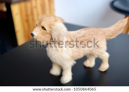 Close up, dog doll standing on black table, decorative at coffee shop with copy space for your text and design. Concept be used for idea of decoration vintage coffee shop and background.Blur picture