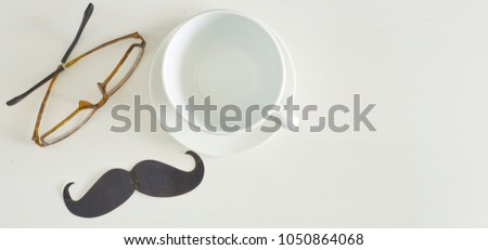 Happy Father's Day inscription with mug and Spectacles on White wooden background. Greetings and presents