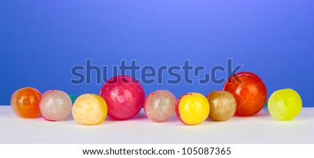 Many delicious lollipops on bright blue background