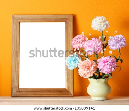 wooden picture frame on orange wall with flowers