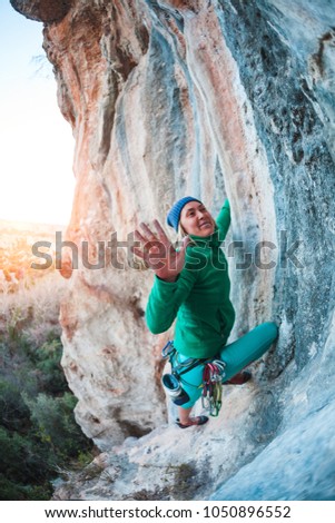 The climber gives five. The woman has overcome the climbing route and is happy with the success. The girl gives five. Gesture of greeting. Fitness in nature.