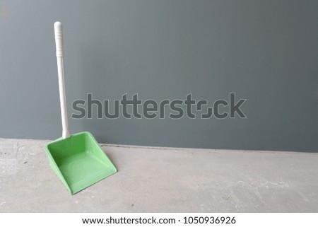 Green dust pan on floor