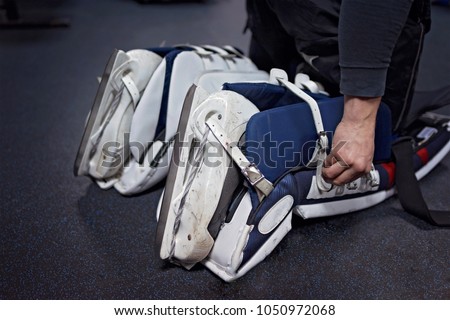 Hockey players are preparing to play in the locker room