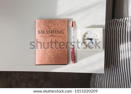 Rose gold glitter notebook and pen on a white table. Woman's stylish accessories. Blogging, freelance, minimalism lifestyle concept
