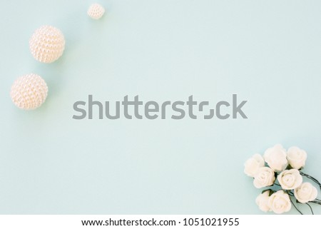 Styled stock photo. Feminine wedding desktop mockup. White roses and beads on delicate blue background. Copy space. Top view. Picture for blog