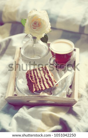 cake with coffee and flower in tray on bed