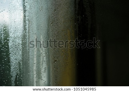 Droplets or drops of water on misted glass. Beautiful background, texture, abstract pattern, copy space. Autumn concept. Window wet after rain. Condensate on glass on blurred background, defocused.