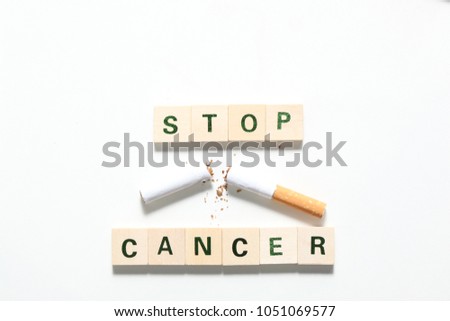 words stop cancer made of wooden  block and a broken cicarette isolated on white background