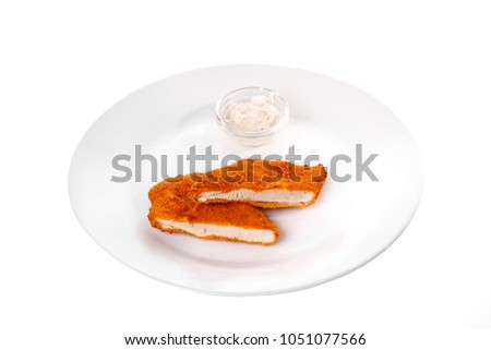 Schnitzel is cut into pieces of chicken, pork, meat, grilled, barbecue, on plate isolated white background. Tartar, sour cream, mayonnaise, white sauce. For the menu in the restaurant, bar. Side view Royalty-Free Stock Photo #1051077566