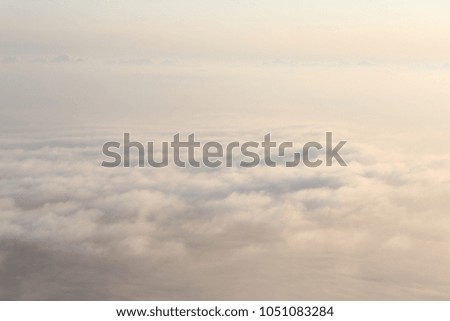 View of clouds from plane in beams of the sunset sun
