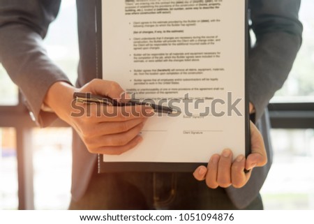 Close up business man reaching out sheet with contract agreement proposing to sign.Full and accurate details, individual who owns the business sign personally,director of the company, solicitor.
